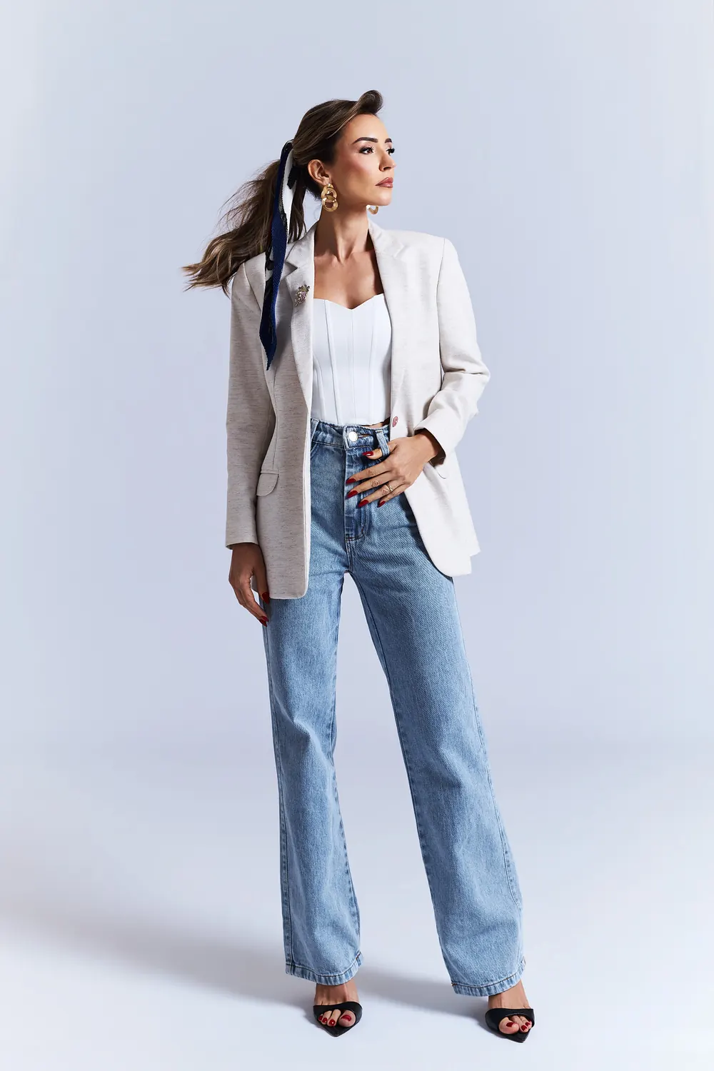 Lara Magri de blazer off-white, calça jeans e lenço no cabelo